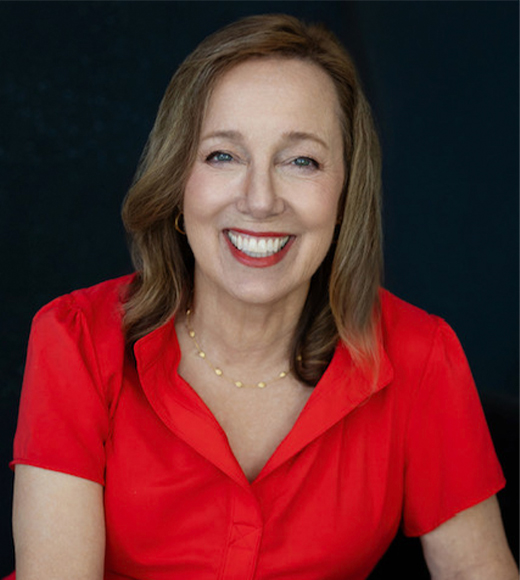 Alison Stewart Cocotis wearing a red blouse and smiling at the camera.