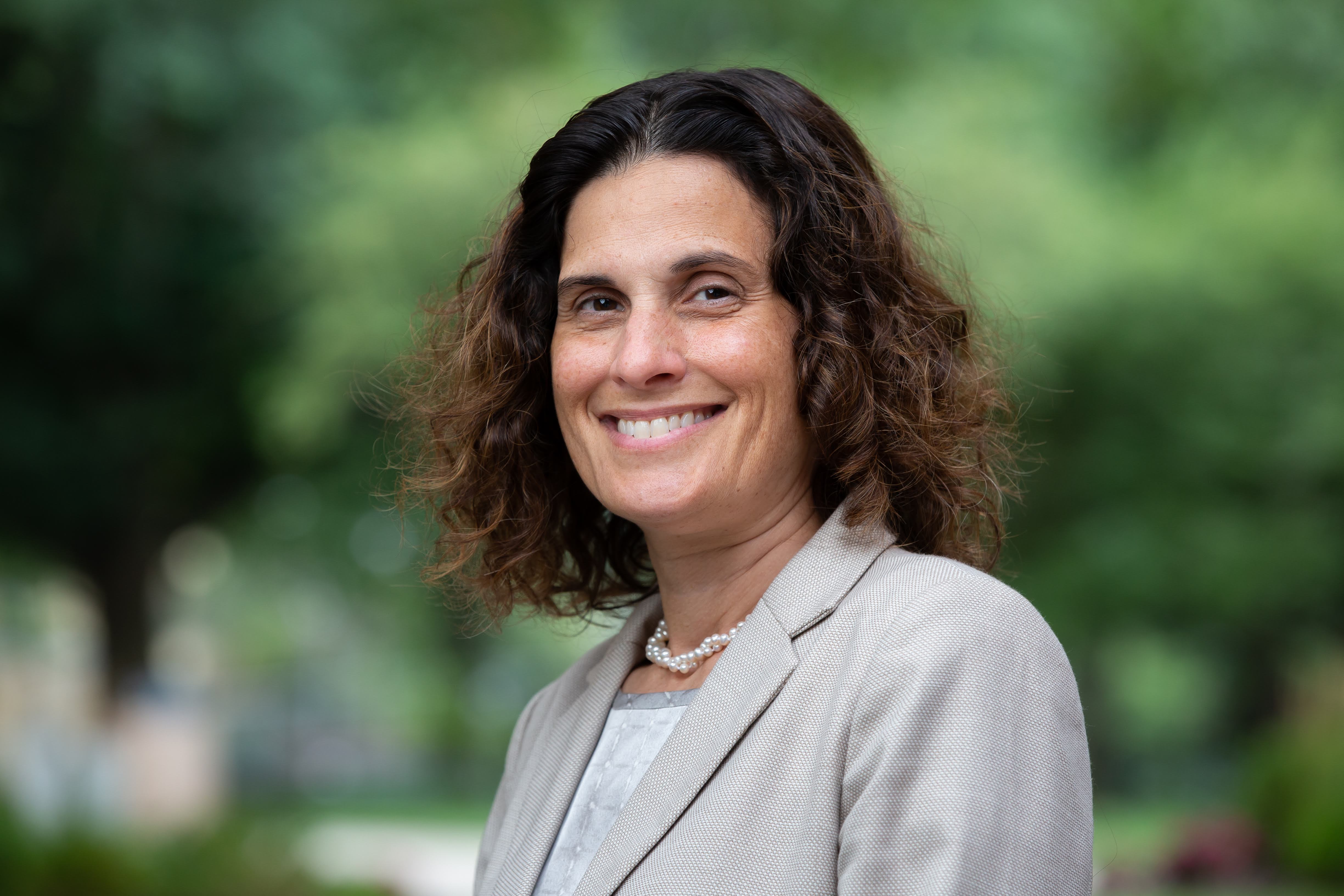 A close-up of Jessica Berg, former dean of the School of Law at Case Western Reserve University, outside wearing a grey suit.