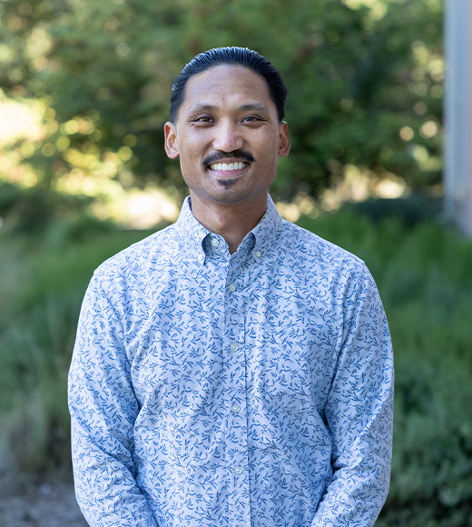 Errol Dauis wearing a button down and smiling at the camera.