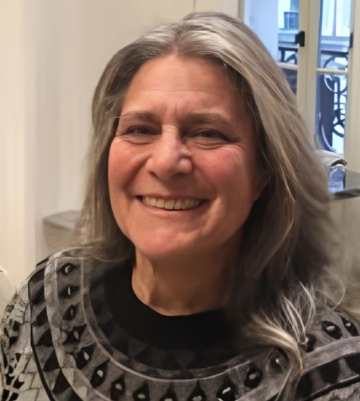 Irene Tresser wearing a grey sweater and smiling at the camera.