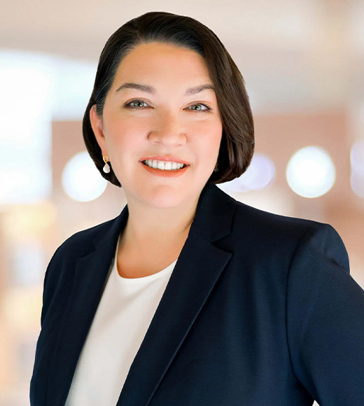 Jennifer Novak wearing a white blouse and black suit jacket. She is softly smiling at the camera.