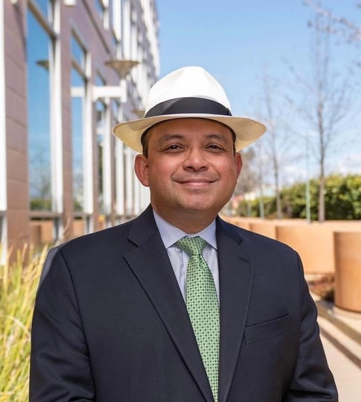 A man wearing a suit and hat. He is smiling at the camera.