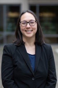Alyssa Thurston, UC Davis Library Director and Lecturer in Law, wearing glasses and a suit, while smiling.