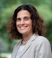UC Davis Law Dean Berg wearing a grey suit and smiling at the camera.