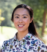Clarisa P. Sudarma, lecturer at UC Davis School of Law, wearing a white and blue blouse while smiling. 