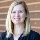 Raelene Dugger, UC Davis Law's Assistant Director of Development, in white. She is softly smiling at the camera.