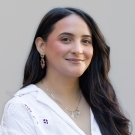 Angelita Mora, International's Admissions and Recruitment Specialist smiling at the camera in front of a white wall.