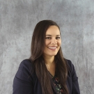 Laura Aranda wearing a black blouse and smiling at the camera.